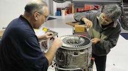 Joe Sabatini, at left, is shown performing a hot section inspection on a J85-5H engine in support of the experimental side of the house.